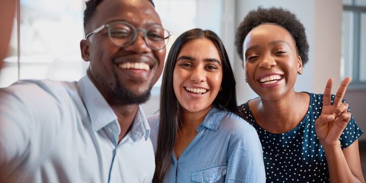 Trio of business coworkers take a silly selfie laughing, smiling at work office Trio of business coworkers take a silly selfie laughing, smiling at work office. High quality photo