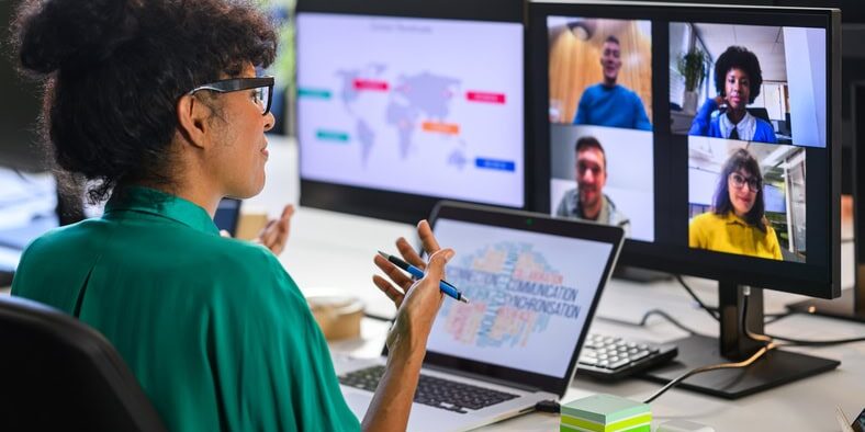 Woman discussing report with remote workers Female business analyst discussing global revenue chart with remote workers team in video call, back side view